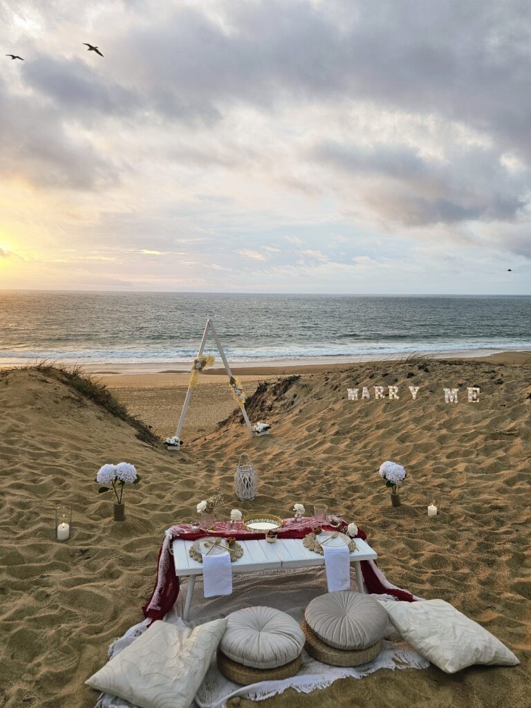 Picnic chic et boheme de demande en mariage, plage coucher de soleil face à l'océan